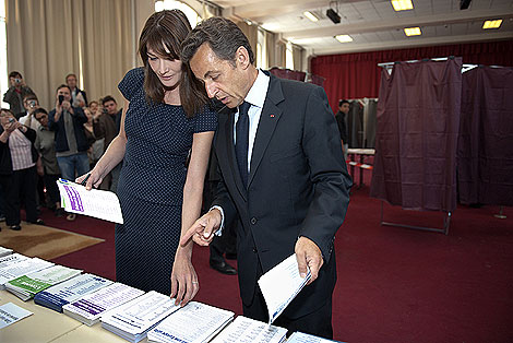 Carla Bruni y Nicolas Sarkozy, revisan las papeletas antes de votar en un colegio electoral de Pars. | Reuters