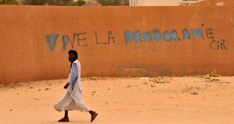 Un mauritano ante una pintada que pide democracia. | Afp