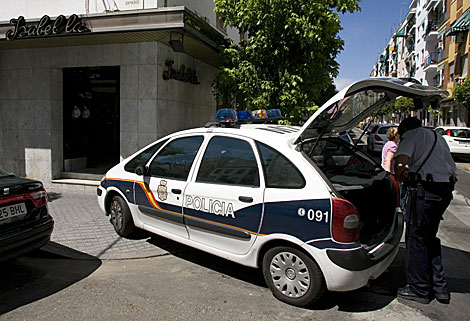 Un agente policial busca algo en el coche patrulla en el lugar de los hechos. | Madero Cubero