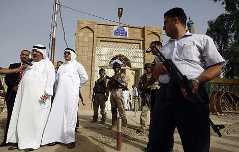Varios diputados iraques hablan con la prensa custodiados por las fuerzas de seguridad junto a la mezquita en la que se produjo el ataque. | AFP