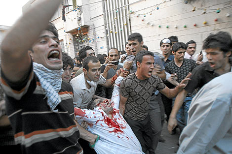 Un grupo de manifestantes traslada el cuerpo de uno de los muertos. | AP