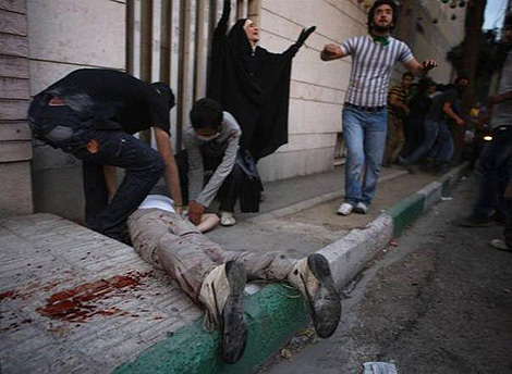 Dos hombres socorren a un manifestante herido en Tehern. | Reuters