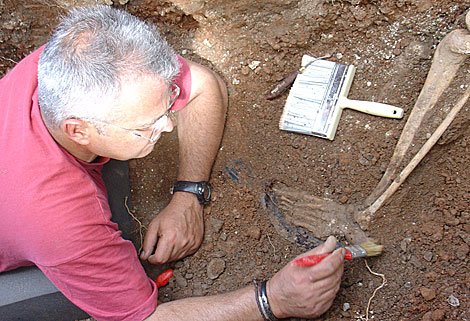 Un voluntario limpia los restos óseos de uno de los milicianos de Melegís. | El Mundo