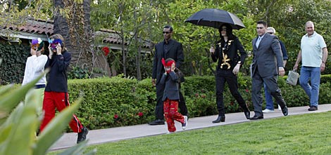 Michael Jackson (con sombrilla) y sus tres hijos en Beverly Hills el pasado mayo. | Efe