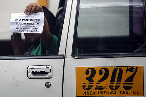 Un taxista exhibe un cartel contra el referndum en Tegucigalpa. | Reuters