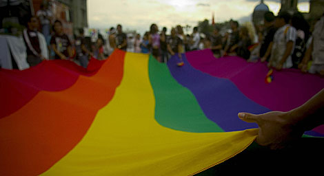 Un grupo de personas sujeta la bandera que identifica al colectivo homosexual. | Efe