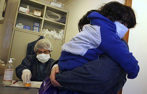 Una mujer y su hijo esperan a ser examinados en un hospital de Buenos Aires. | Reuters