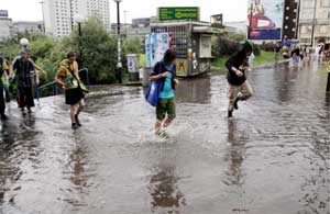 Varias personas se abren paso por las calles inundadas de Varsovia, el 5 de julio de 2009. | Foto: Efe