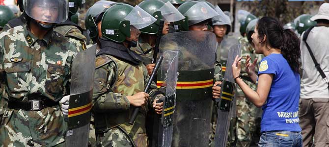Una mujer 'uighur' protesta ante las tropas del Ejrcito chino. | Ap