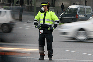 Un agente urbano de movilidad con mascarilla para la polucin en Madrid. | Jos Aym