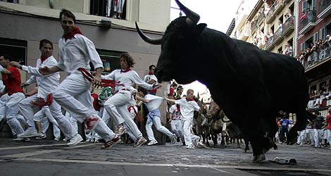 Mozos y toros de Fuente Ymbro en el principio de la calle Estafeta de Pamplona. | Reuters