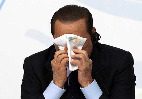 Berlusconi se cubre la cara con un pauelo. | Efe