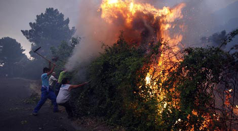 Varios hombres luchan denodadamente contra las llamas | Ricardo Muoz