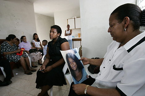 Amalia Savin, con una foto de su hija asesinada, en su entierro en Bonao. | Efe