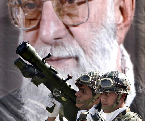 Dos soldados iranes frente a un mural de Jamenei. | Reuters