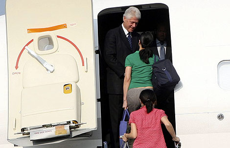 Bill Clinton recibe a las periodistas en la puerta del avión. | AP
