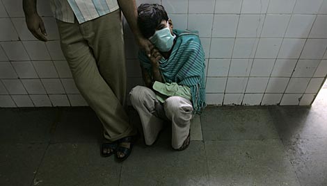 Un hombre con sntomas de gripe A espera en un hospital de Mumbai para ser examinado. | AP