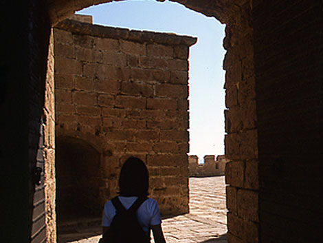 Una joven se recorta contra la antigua fortaleza almeriense.