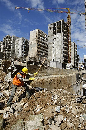 Un obrero trabaja en uno de los edificios que fue destruido en el Lbano por la guerra. (Foto: AFP)