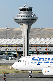 Un avión de Spanair, estacionado junto a la torre de control de la T-4, en el aeropuerto de Barajas. | Alberto di Lolli