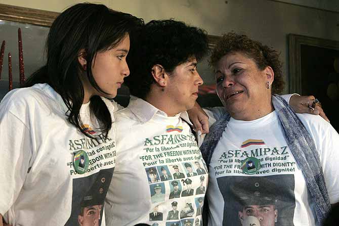 La madre y la hija del cabo Saln Antonio Sanmiguel, secuestrado por las FARC, hablan con la directora de la Asociacin de Familiares de Retenidos y Liberados, Marleny Orjuela (c). | Efe
