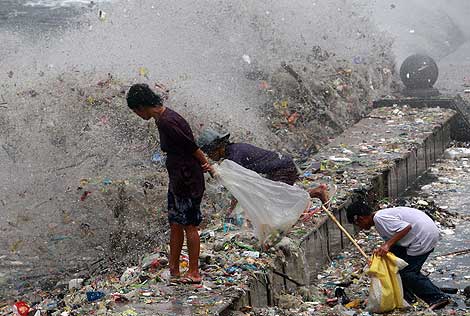 Filipinos hurgan en la basura generada por un fuerte oleaje. | Efe.
