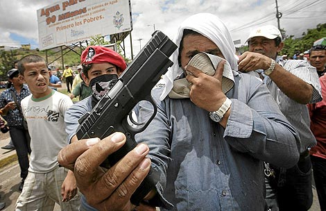 Un manifestante muestra una pistola requisada antes de una manifestacion a un hombre. | Andrs Martnez