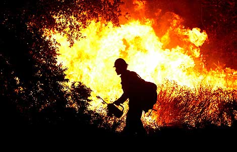 Un bombero luchando contra las llamas. | Afp