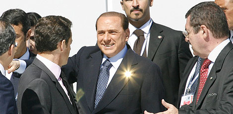 El sol se refleja en la chaqueta de Berlusconi durante la cumbre del G-8 en L'Aquila. | Reuters