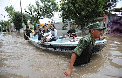 Miembros del Ejrcito mexicano evacan a una familia afectada por las lluvias. | Efe