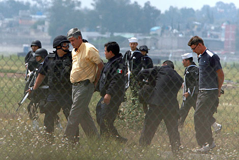 La polica federal escolta a dos de los detenidos. | AFP