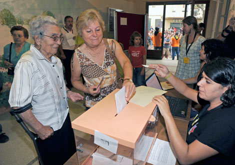 Una vecina del pueblo deposita su voto. | Efe