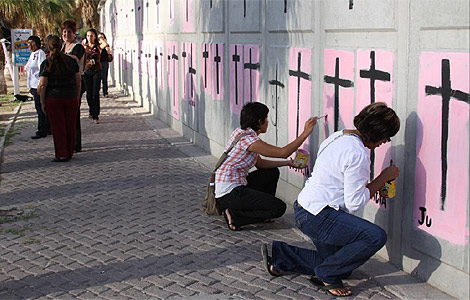 Varias mujeres pintan cruces de protesta en Jurez. | Efe