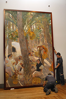 Dos operarios descuelgan uno de los lienzos de Sorolla en El Prado. | Efe