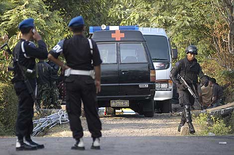 La polica indonesia vigila el lugar donde va a producirse la redada. | Ap