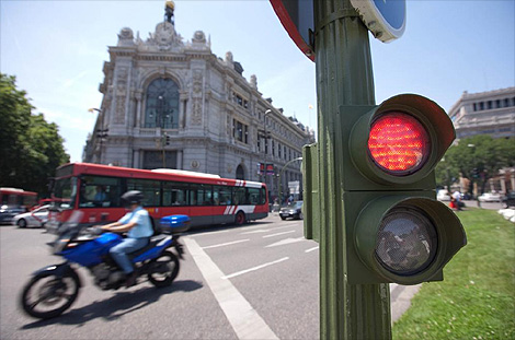 Vehculos a motor circulan tras un semforo en rojo de la madrilea Plaza de Cibeles. | G. Arroyo