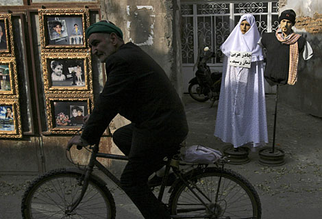 Un hombre pasa en bicicleta ante un maniqu ataviado con el chador en Mashhad (Irn). | AP