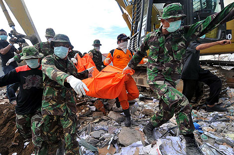 Los equipos de rescate sacan de entre los escombros el cadver de una vctima. | Efe
