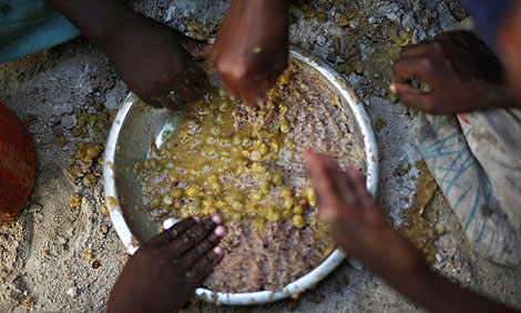 Nios desplazados se sirven comida en Somalia. | AFP