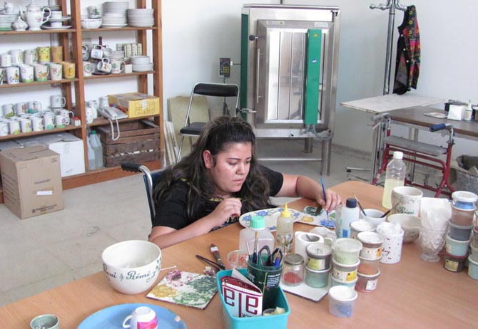 Una mujer trabaja en la decoracin a mano de piezas de cermica.| Mnica G. Prieto