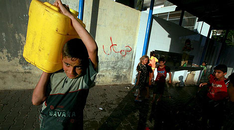 Un nio palestino lleva un bidn de agua en Jan Younis (Gaza). | Efe