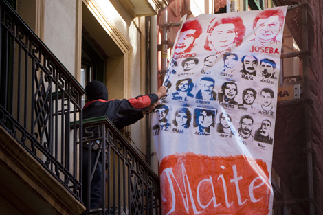 Un ertzaina retira la pancarta donde aparecen los asesinos de Portero. | Carlos Garca