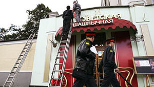 La polica rusa supervisa el desmontaje del letrero 'antisovitico' del restaurante de kebab. | The Moscow News