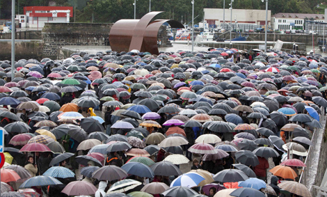 La lluvia no frena a los asistentes que abarrotan el puerto para arropar a las familias. | C. Garca