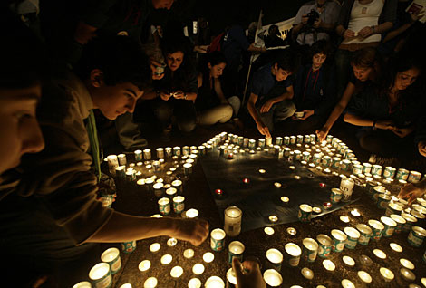Varias personas envienden velas durante el acto de homenaje a Rabin. | Reuters
