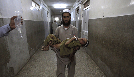 Un padre lleva por el hospital a su hijo herido en el atentado. | Reuters