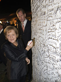Merkel firma en un fragmento del Muro. Afp
