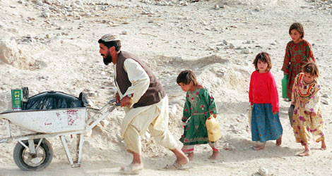 Una familia afgnada transportando agua potable en una carretilla | Afp