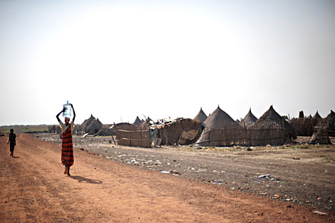Una mujer sudanesa lleva un bidn de agua en la cabeza. | AFP