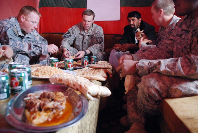 Los soldados estadounidenses disfrutando del almuerzo ofrecido por la policia afgana durante la fiesta del cordero.| Mnica Bernab